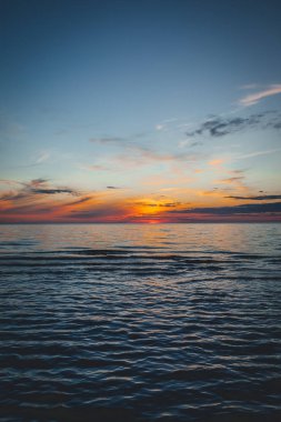 Deniz kenarında bir akşam, Baltık kıyılarında güzel bir gün batımı, küçük dalgalar üzerinde yakın bir manzara.