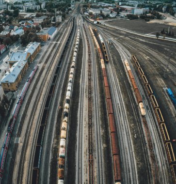 Kargo trenleri yakın plan. Tren istasyonundaki renkli yük trenlerinin hava manzarası. Trenli endüstriyel kavramsal sahne. Uçan İHA 'nın üst görüntüsü