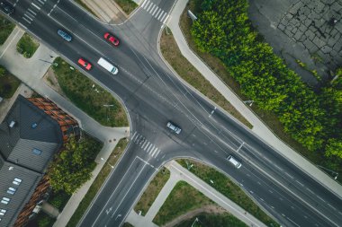 Şehirdeki yol, kavşak ve şehir trafiği, yoldaki arabalar, evlerin çatıları. 