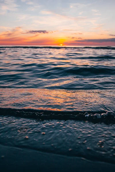 Evening by the sea, beautiful sunset over Baltic sea shore, close up view on small waves