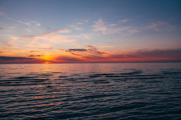 Evening by the sea, beautiful sunset over Baltic sea shore, close up view on small waves