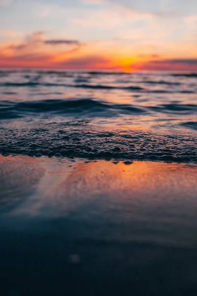 Evening by the sea, beautiful sunset over Baltic sea shore, close up view on small waves