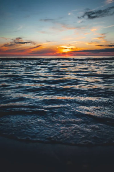 Evening by the sea, beautiful sunset over Baltic sea shore, close up view on small waves