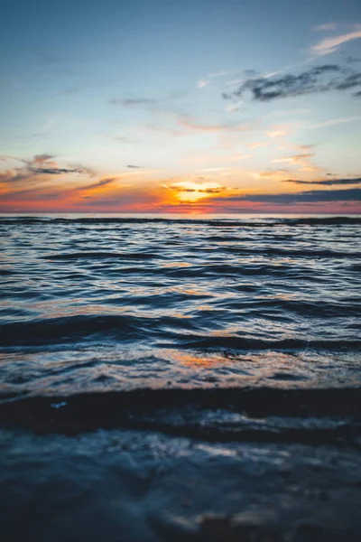 Evening by the sea, beautiful sunset over Baltic sea shore, close up view on small waves