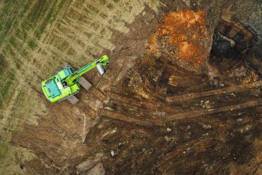 Modern kazıcı tarlada kazı yapıyor.