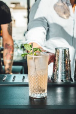 Barmen barda alkollü kokteyl hazırlıyor. 