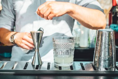 Barmen barda alkollü kokteyl hazırlıyor. 