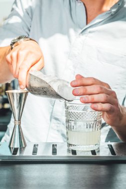 Barmen barda alkollü kokteyl hazırlıyor. 