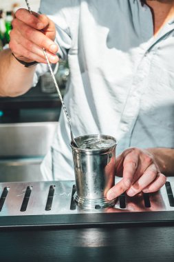 Barmen barda alkollü kokteyl hazırlıyor. 