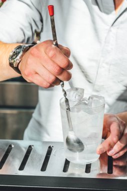 Barmen barda alkollü kokteyl hazırlıyor. 