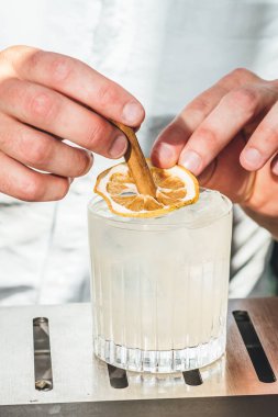 Barmen barda alkollü kokteyl hazırlıyor. 