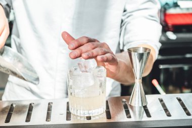 Barmen barda alkollü kokteyl hazırlıyor. 