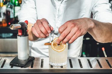 Barmen barda alkollü kokteyl hazırlıyor. 