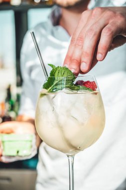 Barmen barda alkollü kokteyl hazırlıyor. 