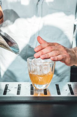 Barmen barda alkollü kokteyl hazırlıyor. 