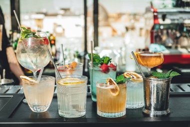 Bar masasında farklı alkollü kokteyller, barmenin yaz kokteylleri.