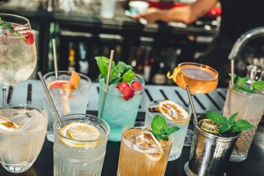 Bar masasında farklı alkollü kokteyller, barmenin yaz kokteylleri.