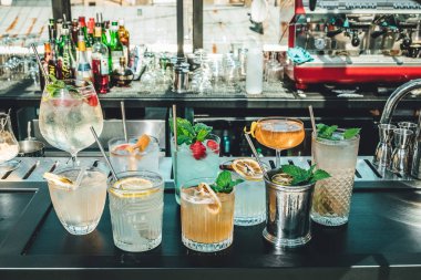 Bar masasında farklı alkollü kokteyller, barmenin yaz kokteylleri.
