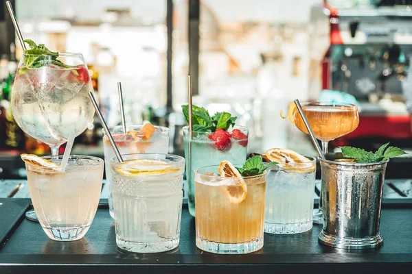 Bar masasında farklı alkollü kokteyller, barmenin yaz kokteylleri.