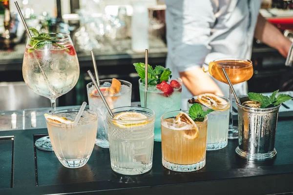 Bar masasında farklı alkollü kokteyller, barmenin yaz kokteylleri.