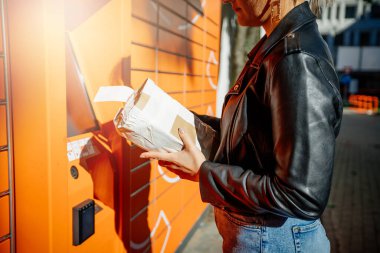 Genç kadınlar posta göndermek için halka açık paket makinesini kullanıyorlar