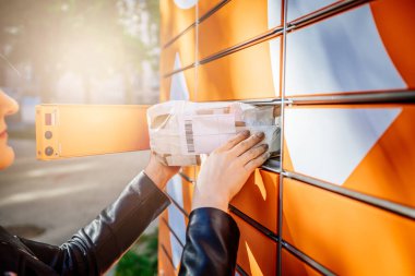 Genç kadınlar posta göndermek için halka açık paket makinesini kullanıyorlar