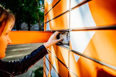 Genç kadınlar posta göndermek için halka açık paket makinesini kullanıyorlar
