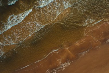 Yukarıdan deniz kulaklıkları, dalgalar ve köpüklerin sahile çarpması, güzel dokular, desenler oluşturur..