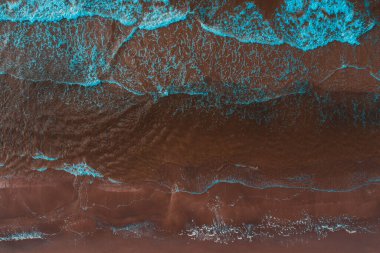 Yukarıdan deniz kulaklıkları, dalgalar ve köpüklerin sahile çarpması, güzel dokular, desenler oluşturur..