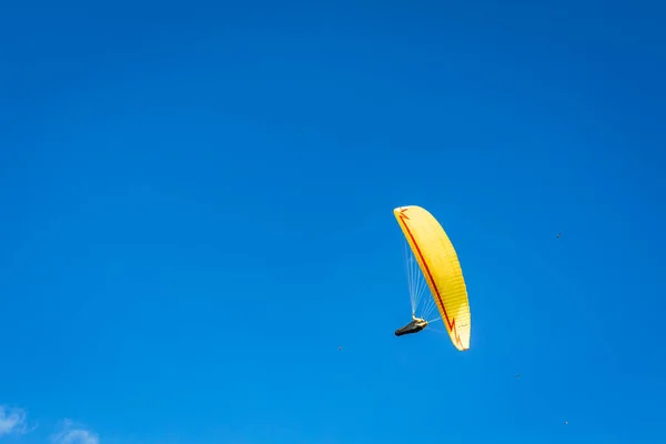 滑翔伞一种滑翔伞 有明亮的黄色降落伞 衬托着蓝蓝的天空 — 图库照片