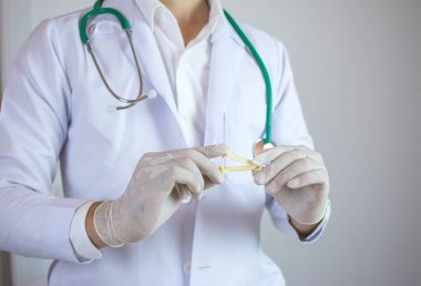 bir bebeğin doğumdan sonra göbek kordonu kelepçe için kullanılan sarı göbek kordonu kelepçe tutan doktor.