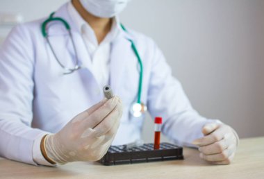 Doktor bir kan örneği tüp laboratuvarda test elinde tutan