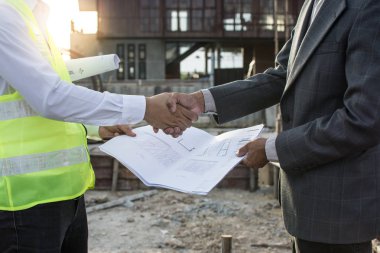 Mühendis ve mimar bittikten sonra el sıkışan inşaat alanında Toplantı 