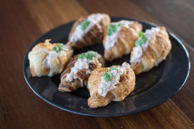 Ton balıklı salata sandviç ile kruvasan ahşap masa üzerinde