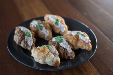 Ton balıklı salata sandviç ile kruvasan ahşap masa üzerinde