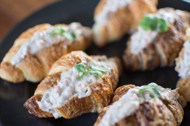 Ton balıklı salata sandviç ile kruvasan ahşap masa üzerinde