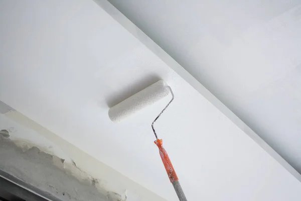 Peinture d'un plafond en plâtre de gypse blanc avec rouleau de peinture — Photo