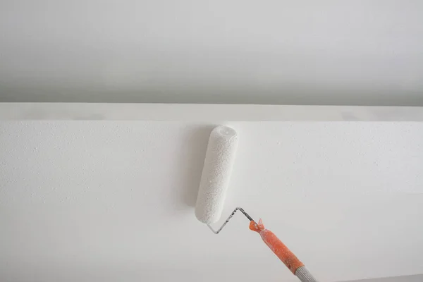 Peinture d'un plafond en plâtre de gypse blanc avec rouleau de peinture — Photo