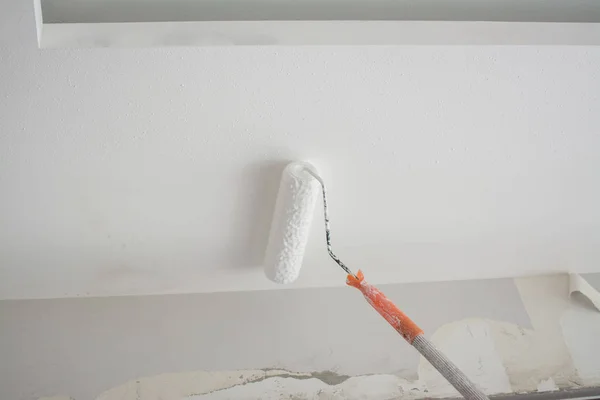Malowanie białego gipsu sufit gipsowy z walec malarski — Zdjęcie stockowe