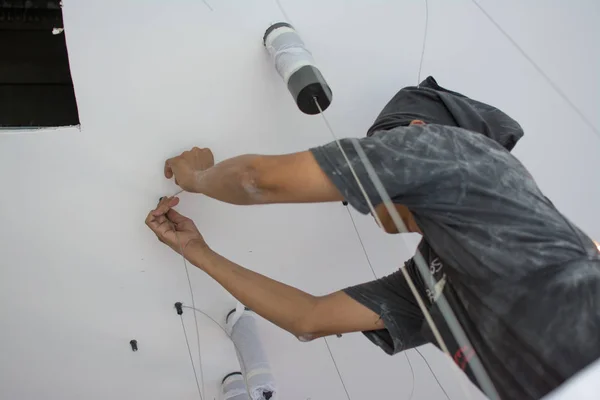 Homem instalar lâmpada pendurada no teto — Fotografia de Stock
