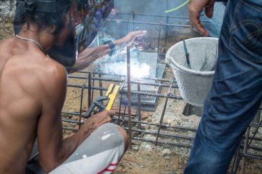 İnşaat alanında işçiler çelik kaynakçılığı yapıyor.