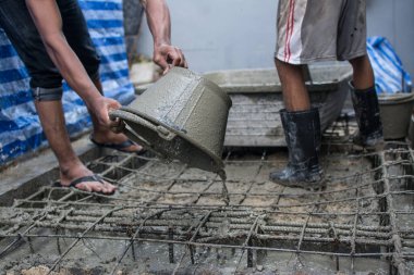 İnşaat alanında beton döken işçiler