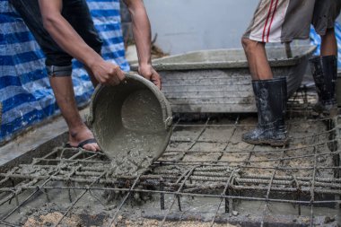 İnşaat alanında beton döken işçiler