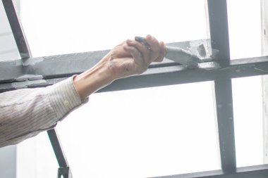 Çelik çatıyı boyayan işçiler, çatının altında..