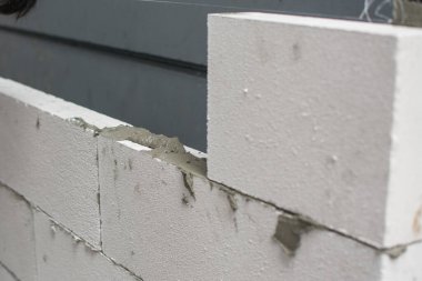 İnşaat ustası tuğla ustası mala ve çimento harcı ile tuğla işi yapıyor.