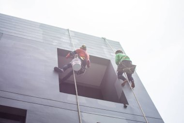 Boyacılar ve kayışlar inşaat alanında yüksek bina, el fırçası renk iş konsepti