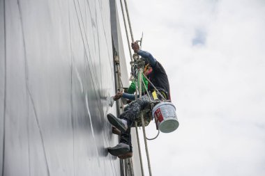 Boyacılar ve kayışlar inşaat alanında yüksek bina, el fırçası renk iş konsepti