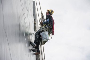 Boyacılar ve kayışlar inşaat alanında yüksek bina, el fırçası renk iş konsepti