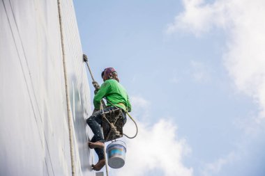 Boyacılar ve kayışlar inşaat alanında yüksek bina, el fırçası renk iş konsepti