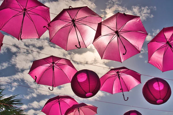 Güneşli mavi gökyüzüne doğru süzülen pembe şemsiyelere bakıyorum. Kanser farkındalığını fark ediyorum.